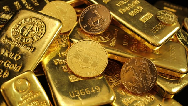 Detailed close-up of gold bars and coins, symbolizing wealth and investment. Perfect for financial imagery.