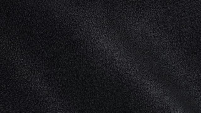 Detailed view of black textile fabric showing soft waves and texture.