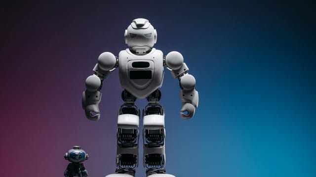 Close-up shot of two white robots displayed on a colorful gradient background symbolizing innovation in robotics.