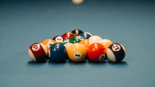 Close-up view of colorful billiard balls arranged for a pool game. Depth of field emphasizes the arrangement.