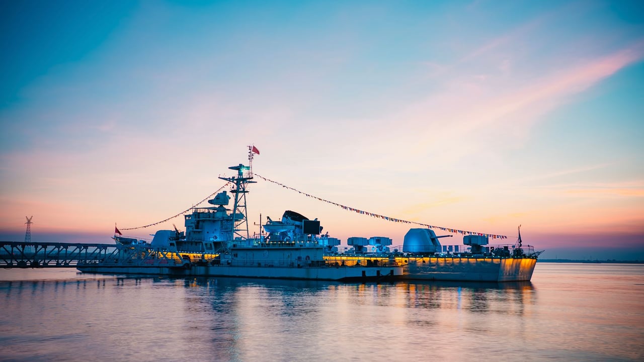 Beautiful view of a warship displayed against a twilight sky over calm waters, exuding serenity and strength.
