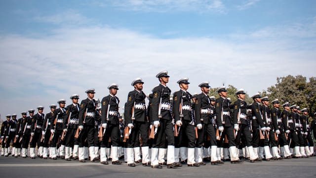 Indian naval officers in uniform marching in formation, showcasing discipline and unity during a parade in New Delhi.