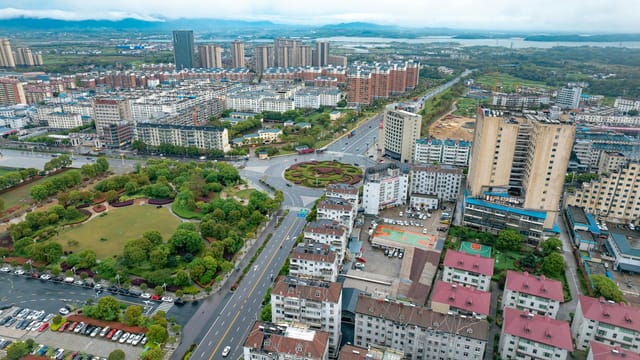 Aerial photograph capturing the vibrant cityscape of Jiujiang, Jiangxi, China showcasing residential and commercial buildings.