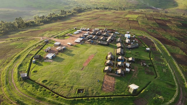 A bird's eye view of a rural village surrounded by lush fields in Santiago, Dominican Republic.