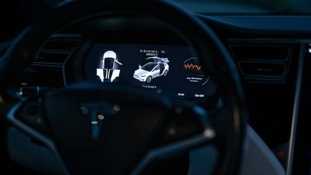Close-up of a Tesla Model X dashboard display, showcasing advanced technology features.