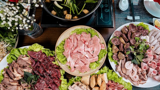 A variety of fresh meat and vegetables for making a traditional Asian hotpot meal.