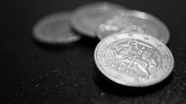 Macro photograph of stacked coins in black and white, highlighting finance and wealth.