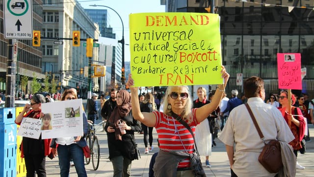 Demonstrators gather in Vancouver advocating for universal political rights. Peaceful protest captured during the day.