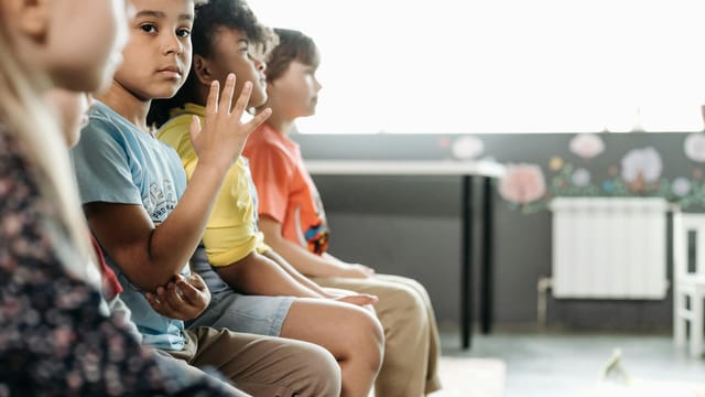 Children of diverse backgrounds sitting in a classroom, capturing innocence and togetherness.