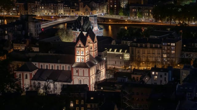 Stunning aerial view of Liège Cathedral illuminated at night, showcasing gothic architecture in Belgium's Wallonia region.