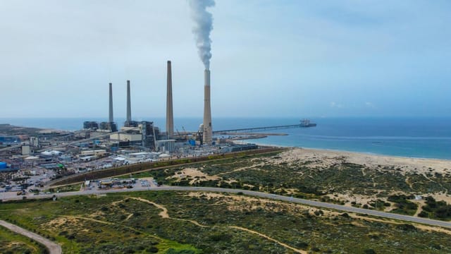 Aerial view of the Hadera power plant with smoke stacks by the Mediterranean Sea in Israel.