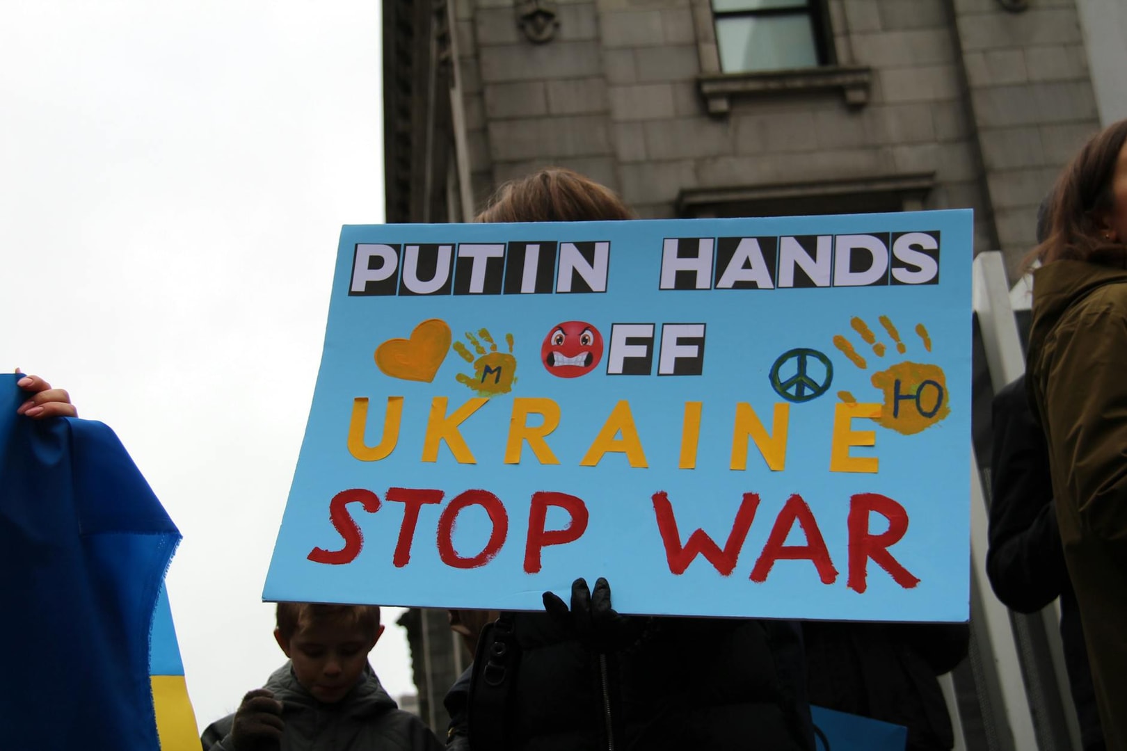 Protesters in Vancouver hold signs advocating peace and opposing war in Ukraine.