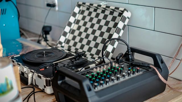 Professional mixer and turntable setup in a modern indoor setting for music production.