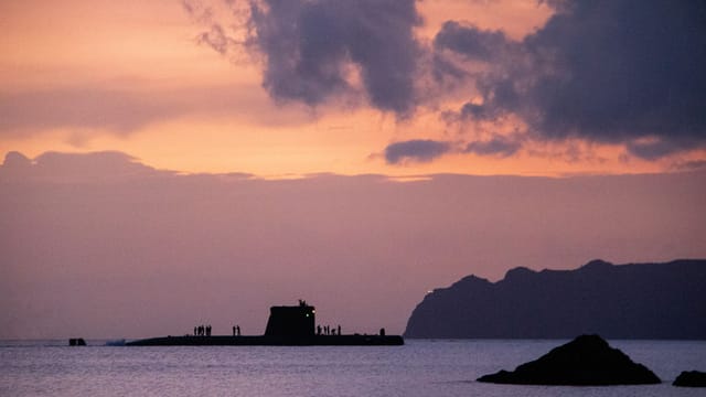 A submarine silhouetted against a stunning sunset sky over the sea near Cartagena, Spain.