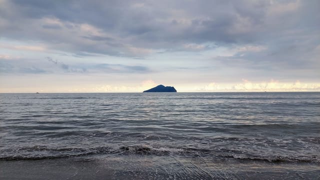 Beautiful coastal view of Guishan Island from Yilan, Taiwan with serene sea and cloudy sky.