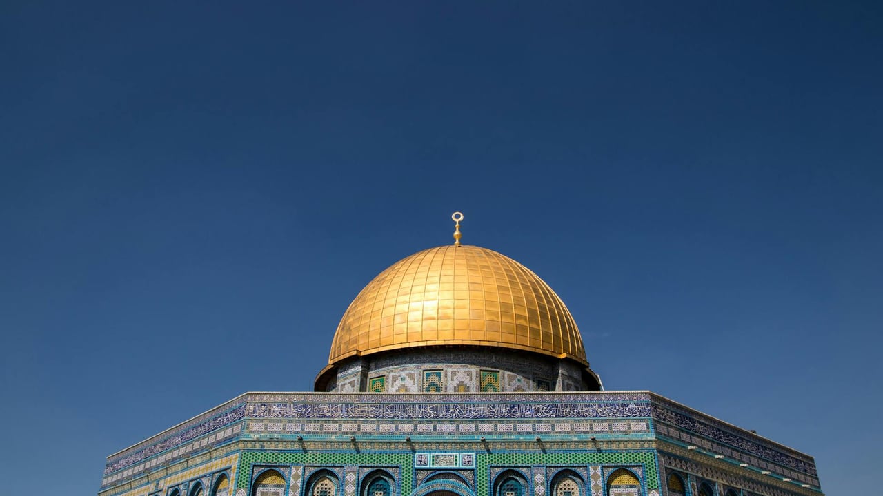 The stunning Dome of the Rock with its golden dome under a clear blue sky in Jerusalem.