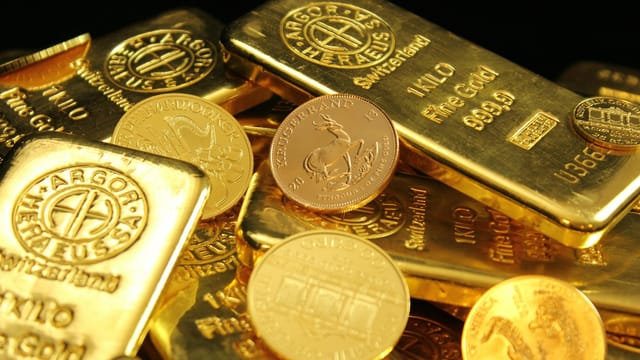 A detailed image of gold bars and coins symbolizing wealth and financial investment.