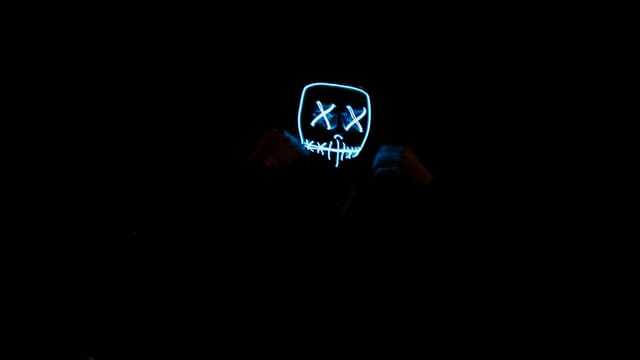 A glowing LED mask in a dark environment creates a mysterious and eerie atmosphere.