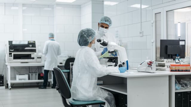 Laboratory scientists conduct research using advanced microscopes in a well-equipped lab.