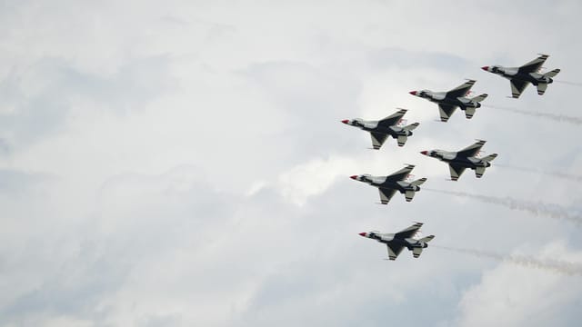 A striking view of fighter jets flying in formation against a clouded sky.