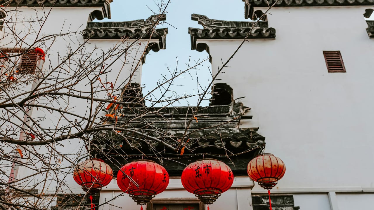 A view of traditional Chinese architecture with red lanterns in Nanjing during autumn.