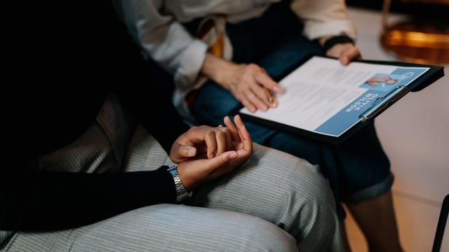 Two professionals reviewing a resume in an office setting, focused on teamwork.