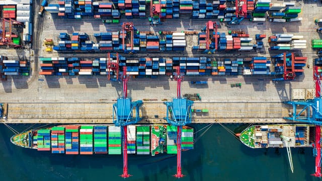 Drone shot capturing vibrant container ships and dock in North Jakarta port, Indonesia.