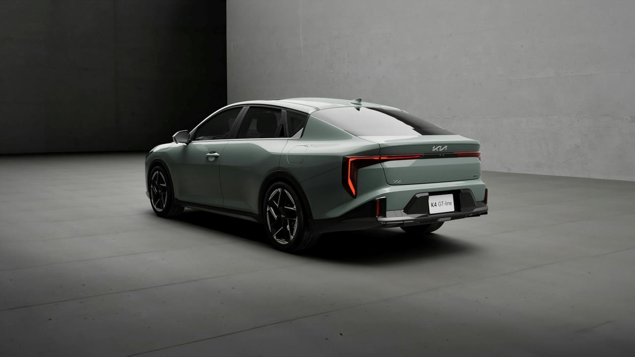 A modern gray Kia K4 GT Line vehicle in a minimalist indoor environment.