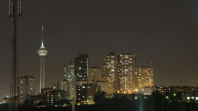 A stunning night view of Tehran's skyline with the iconic Milad Tower prominently visible.