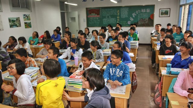 A lively classroom in Tianjin, China, with enthusiastic students participating in a lesson.