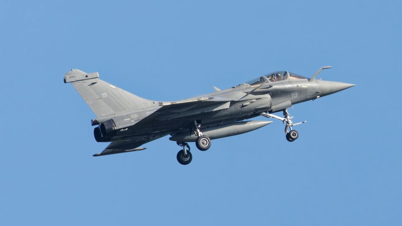 A sleek military jet flying high in the clear blue sky, showcasing aerodynamic design and power.