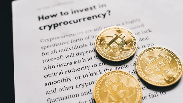 Close-up of Bitcoin coins on an investment guide paper.