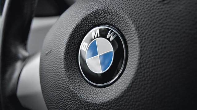 Detailed view of a BMW steering wheel with focus on the emblem showcasing luxury and design.