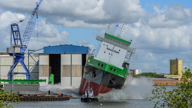 Dramatic ship launch at a port in Niedersachsen, Germany, capturing a vessel entering the water.