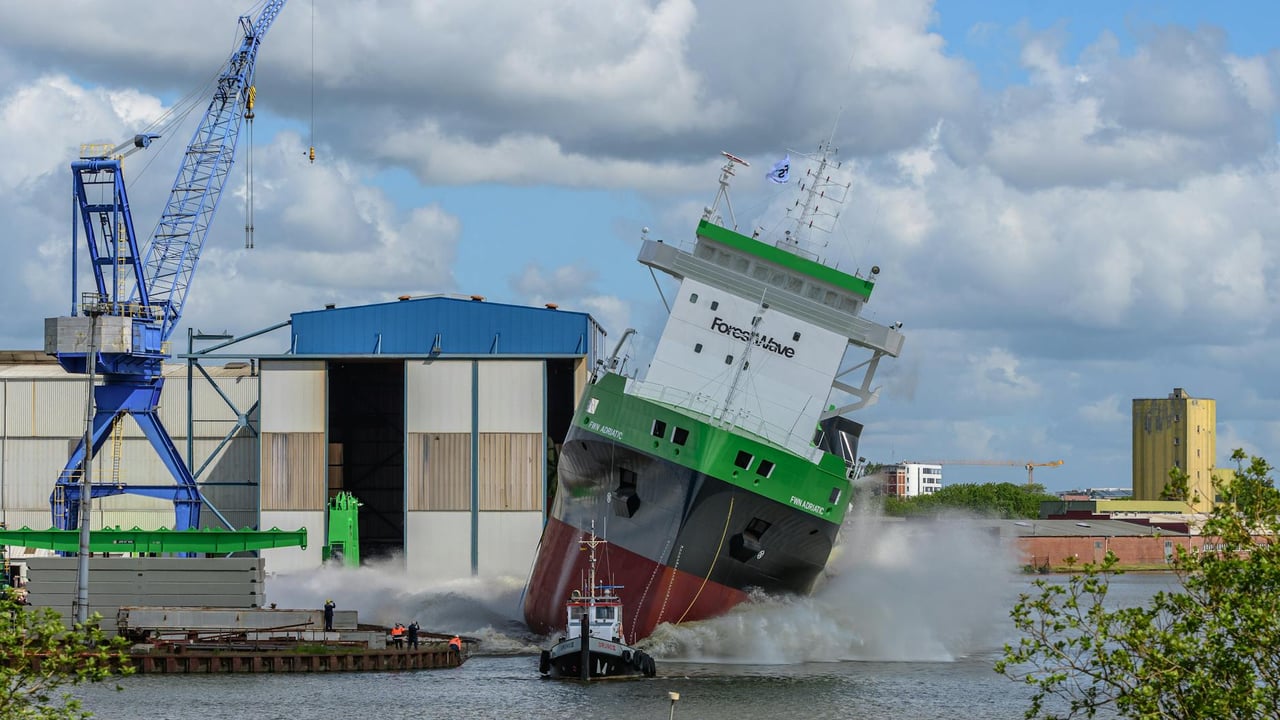 Dramatic ship launch at a port in Niedersachsen, Germany, capturing a vessel entering the water.