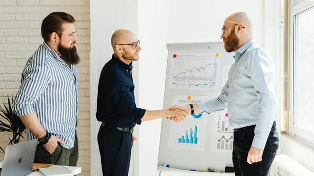 Three business colleagues engage in a productive meeting, exchanging ideas with data charts.