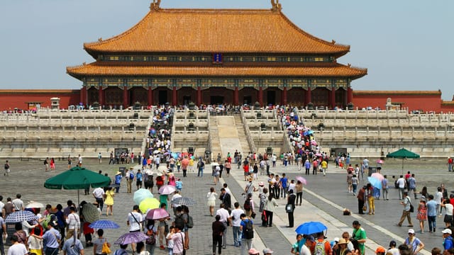 Crowds visiting the historic Forbidden City in Beijing, China on a sunny day.
