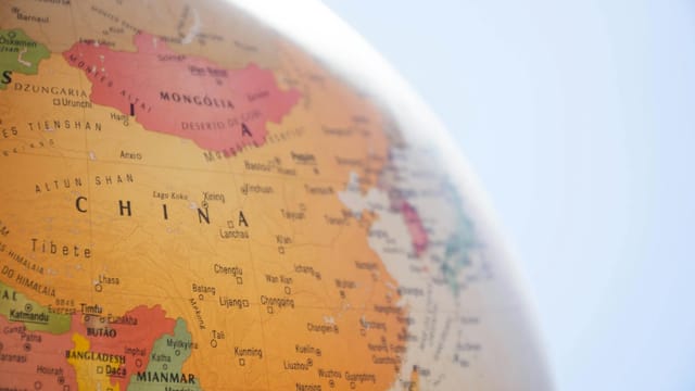 Detailed close-up of a globe showing China and surrounding regions, with geographic labels in focus.