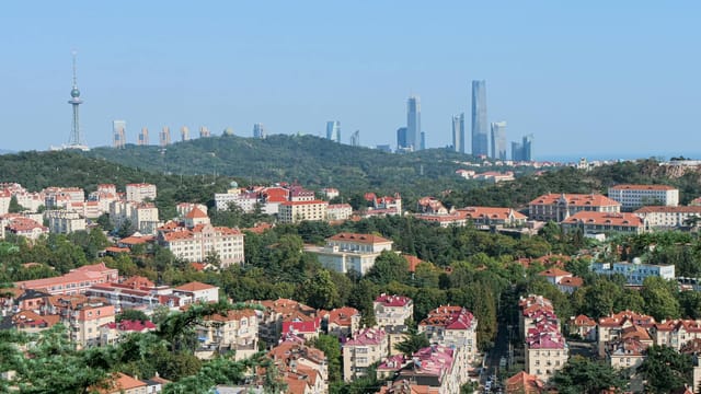 Panoramic view over Qingdao cityscape featuring iconic landmarks and urban landscape.