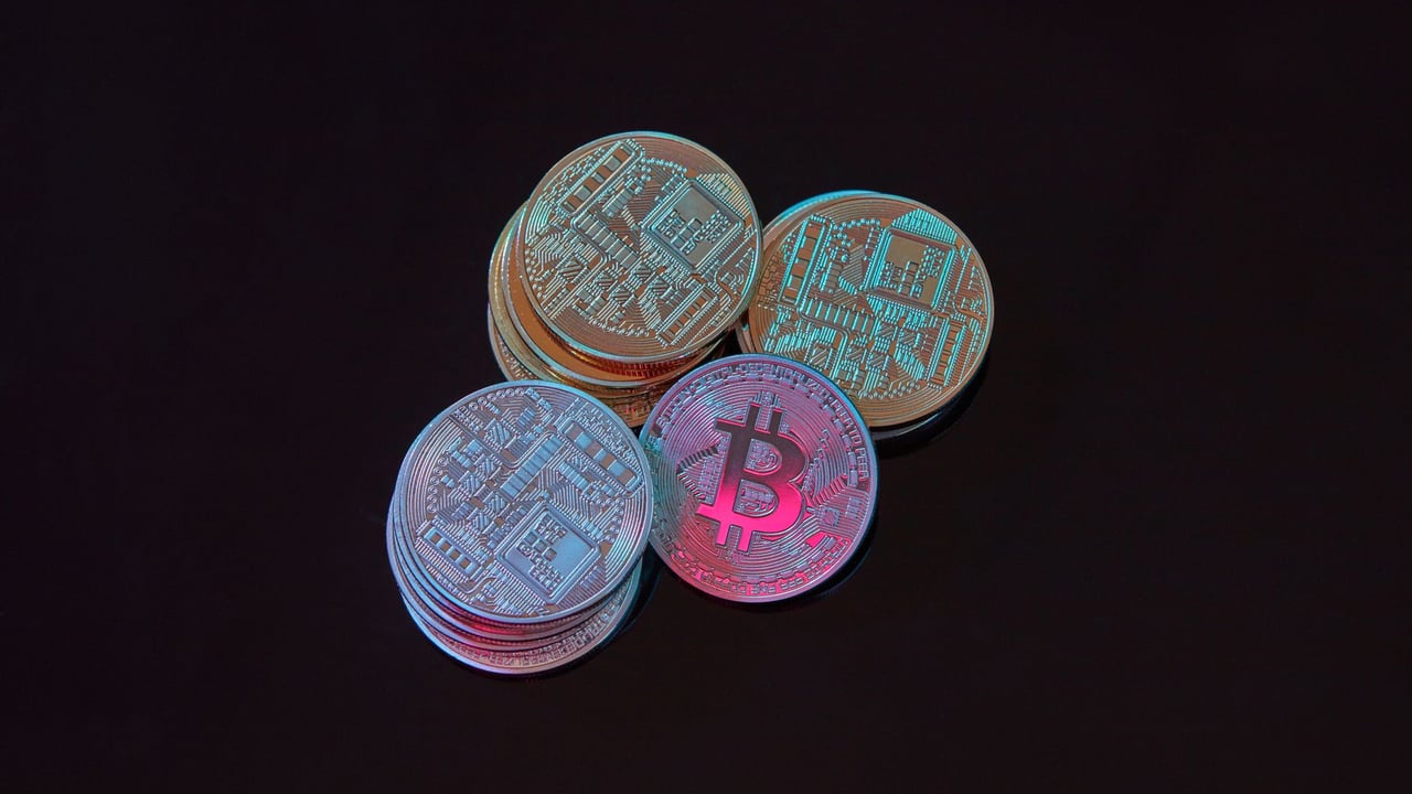 A detailed image showcasing a stack of Bitcoin cryptocurrency coins on a black background.