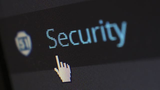 Illustrative image: Close-up view of a mouse cursor over digital security text on display.
