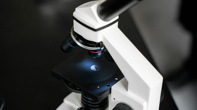 Close-up view of a laboratory microscope with selective focus, ideal for scientific use.