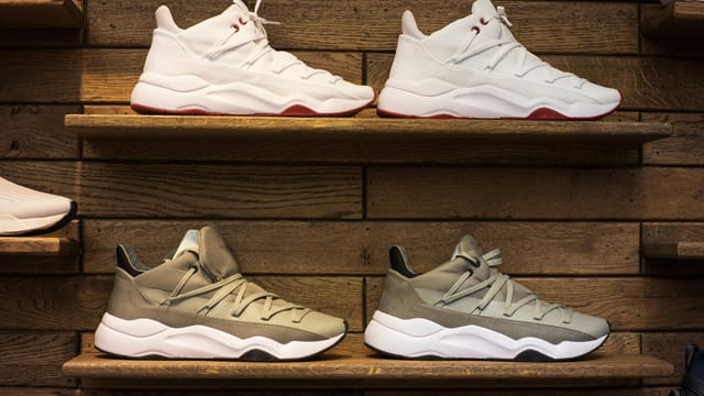 Modern sneakers showcased on wooden shelves in a stylish display setting.