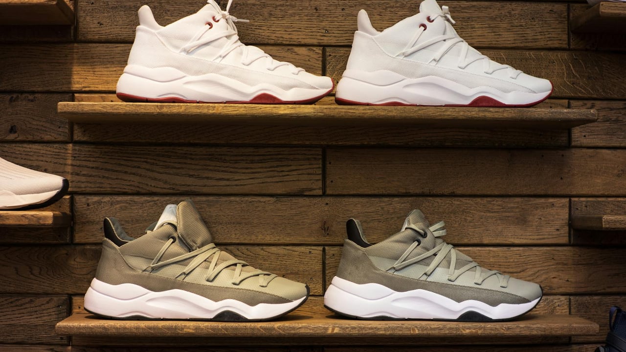 Modern sneakers showcased on wooden shelves in a stylish display setting.