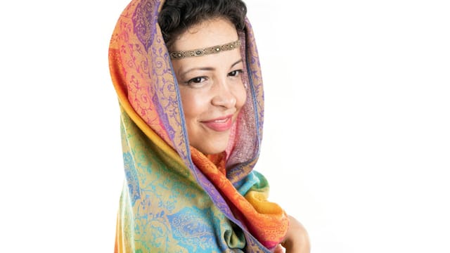 Vibrant portrait of a woman wearing a colorful headscarf, exuding warmth and beauty.