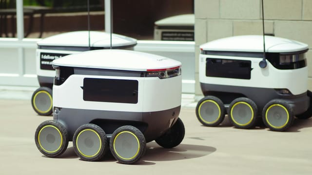 Advanced autonomous delivery robots in an outdoor urban setting, showcasing modern technology.