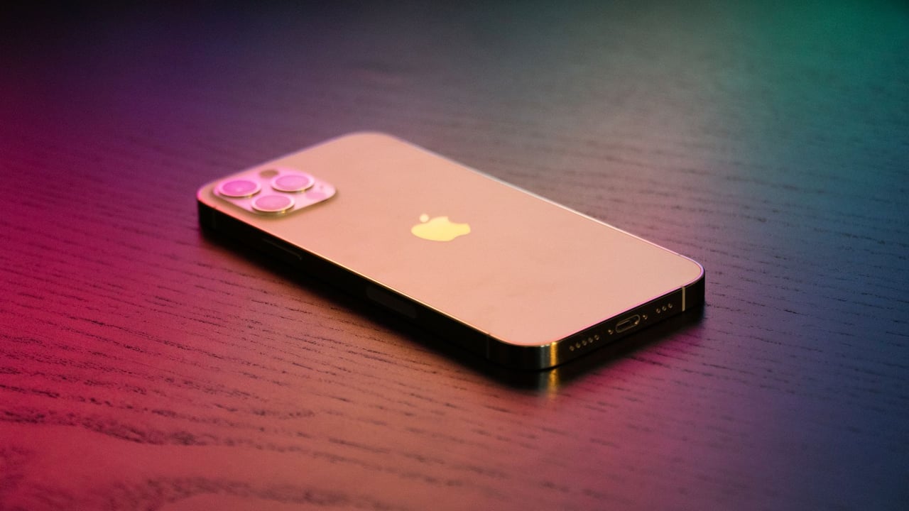 Close-up of a modern smartphone on a gradient-lit wooden surface, showcasing elegance.