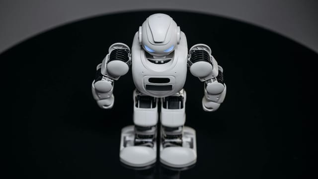 A detailed view of a white robot toy standing on a black surface, showcasing modern toy technology.