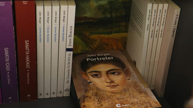 Bookshelves with a selection of John Berger's books featuring an artistic portrait cover.