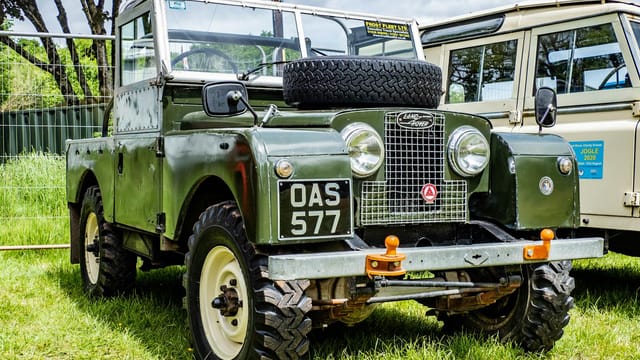 Vintage Land Rover Series vehicle parked outdoors, showcasing classic design.